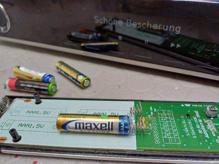 Fernbedienung mit einem kleinen Schaden durch ausgetretenes Elektrolyt der Batterie.<br>
Hinweis: Wenn Sie ein Gerät länger nicht verwenden, z. B.: weil dieses defekt ist, entfernen Sie die Batterien aus der Fernbedienung. 