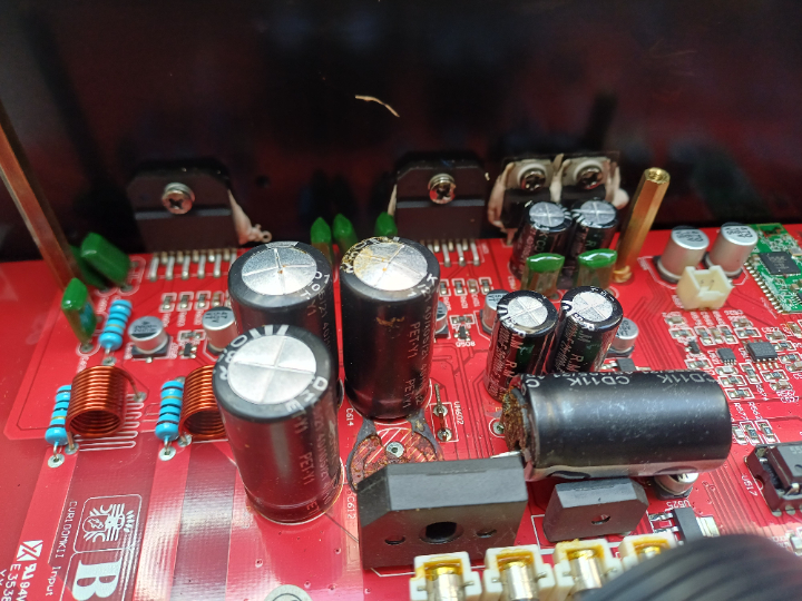 Geblähte Elektrolytkondensatoren, zusätzlich sind die Anschlussdrähte durch ausgetretenes Elektrolyt oder die Säure des Kontaktklebers durchoxidiert.